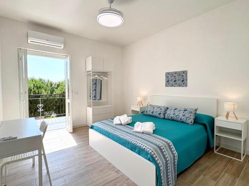 a bedroom with a bed and a desk and a window at B&B Salty Mermaid in Tropea
