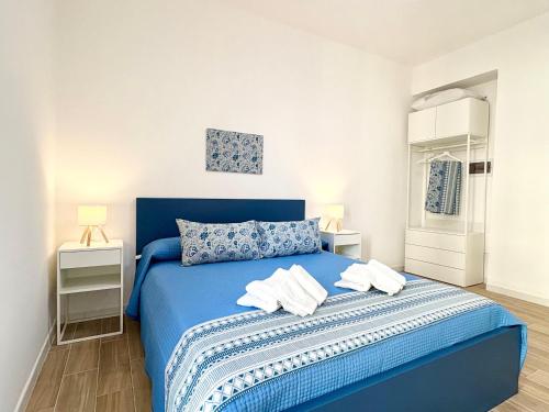 a bedroom with a blue bed and two night stands at B&B Salty Mermaid in Tropea