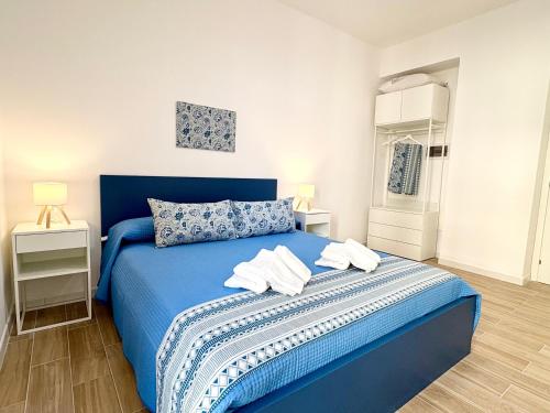 a bedroom with a blue bed with towels on it at B&B Salty Mermaid in Tropea