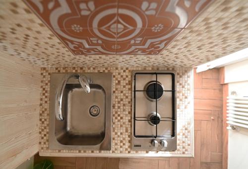 a bathroom with a sink on a tiled wall at Nei pressi dei Sassi in Matera