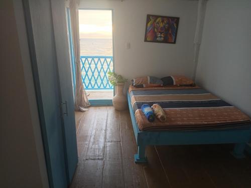 a bedroom with a bed with a view of the ocean at Renacer ancestral Barú in Playa Blanca