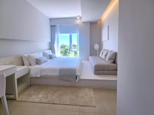 a white bedroom with a bed and a window at 金樽川三白秘境莊園 in Donghe
