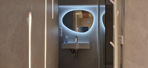 une salle de bain avec un lavabo et un miroir dans l'établissement C'Châtelet, à Chartres