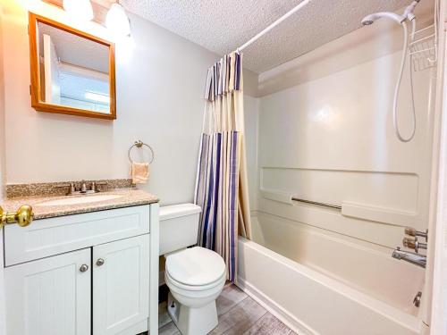 a bathroom with a toilet and a sink and a tub at Grand Strand Resort II 18 in North Myrtle Beach