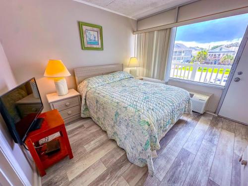a small bedroom with a bed and a window at Grand Strand Resort II 18 in North Myrtle Beach