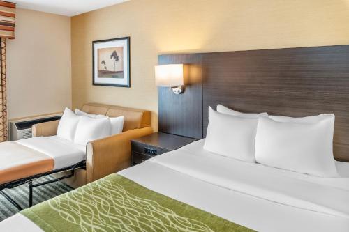 a hotel room with two beds and a chair at Comfort Inn in Chatham