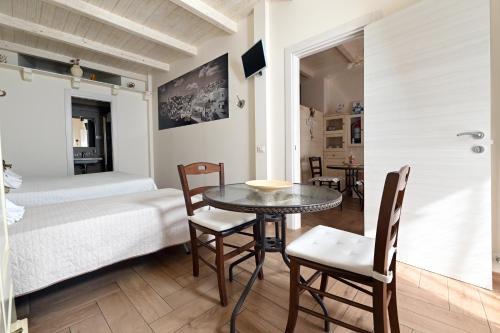 a room with a bed and a table and chairs at Nei pressi dei Sassi in Matera