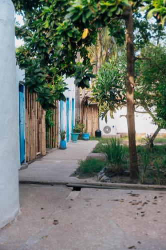 a sidewalk with trees and a building with blue doors at Oasis beach resort in Cape Coast