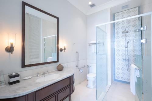 a bathroom with a sink and a shower with a mirror at Rumah Luwih Bali in Keramas