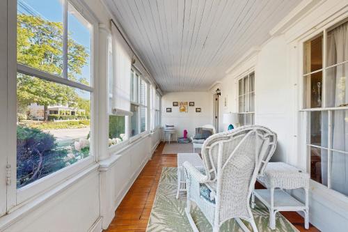 an empty porch with white chairs and windows at Norwood Curtis House in Camden