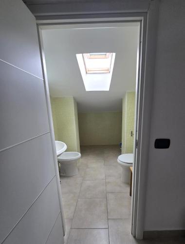 an attic bathroom with two toilets and a skylight at Caly Home in Caserta
