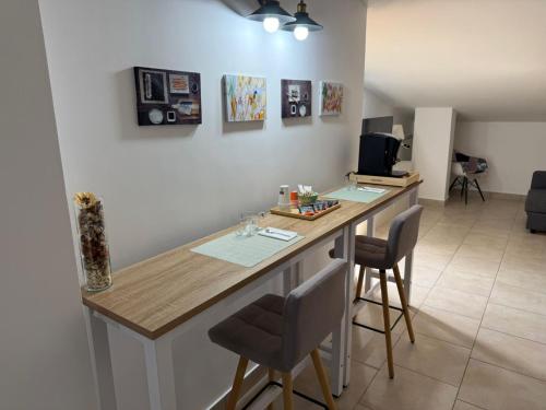 a kitchen with a counter with chairs and a desk at Caly Home in Caserta