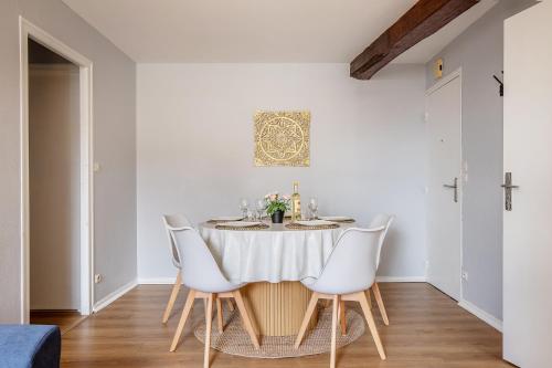 a dining room with a table and white chairs at Chez Ismarita & Jérôme - Tout Dax à pied - Wifi in Dax