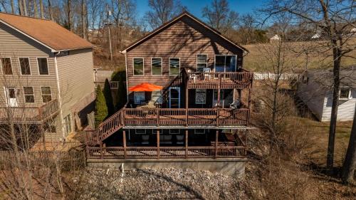 サマセットにあるLake It Easy 3 Level Home with Hot Tub and Game Spaceのオレンジ色の傘が付いた大きなデッキのある家