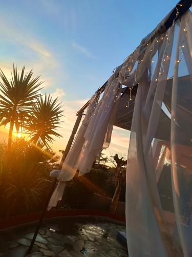 a white curtain hanging over a pool with palm trees at Edem House - Volos Greece in Volos