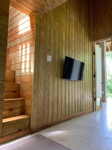 a room with a television on a wooden wall at Indómito Chalet-El Yunque Zone in Juncos