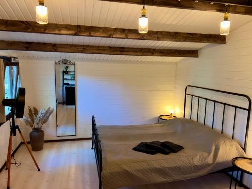 a bedroom with a bed and a camera on a tripod at Baltic Beach Charm Tiny House C in Pērkone