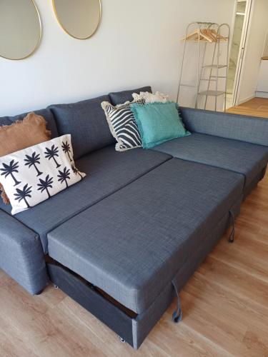 ein blaues Sofa mit Kissen darauf im Wohnzimmer in der Unterkunft Villa Rica in Azeitão
