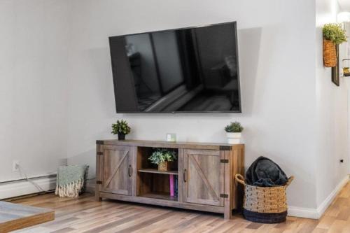 a living room with a television on a wall at Cozy & Spacious 2BR in Downtown very close to Stampede and 17th Ave with Parking and AC in Calgary