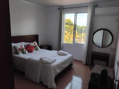 a bedroom with a bed with a mirror and a window at Le Maho AHAVAH in Trou dʼ Eau Douce