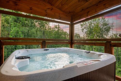 een groot bad in een kamer met bomen bij Friends in Bear Places By Avada Properties in Greystone Heights