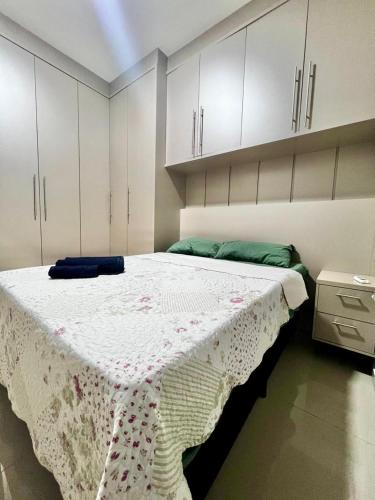 a bedroom with a large bed with a flowered blanket on it at Casa Aconchegante Saboto in Foz do Iguaçu