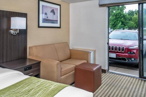 a hotel room with a bed and a couch and a car at Comfort Inn in Chatham