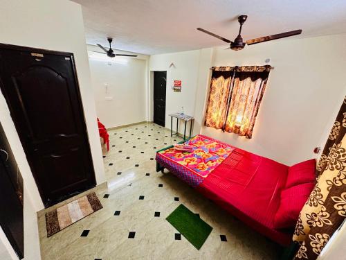 a living room with a red bed in a room at Aravind Guest House in Chidambaram