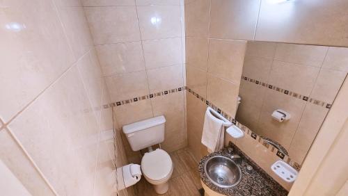 a small bathroom with a toilet and a sink at Diez ApartHotel in Puerto Madryn