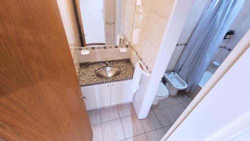 a bathroom with a sink and a toilet at Diez ApartHotel in Puerto Madryn