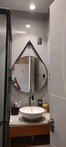 a bathroom with a sink and a large mirror at Suíte Luxo na Casa 68 in Belém