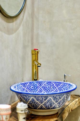 a blue and white sink with a gold faucet at Riad AL-Ghazlan Hamam & Spa in Marrakech