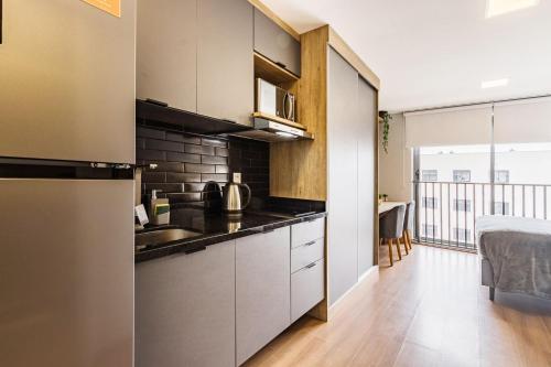 a kitchen with stainless steel appliances and a balcony at GO 24 by My Way in Porto Alegre