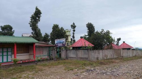 a row of houses with red roofs behind a fence at Ribsweet Treetops Bed and Breakfast in Pynursla