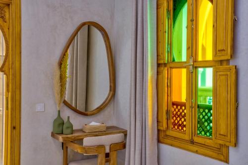 a bathroom with a mirror and a table and a window at Riad AL-Ghazlan Hamam & Spa in Marrakech