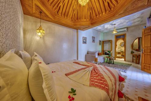 a bedroom with a large bed with a wooden ceiling at Riad AL-Ghazlan Hamam & Spa in Marrakech