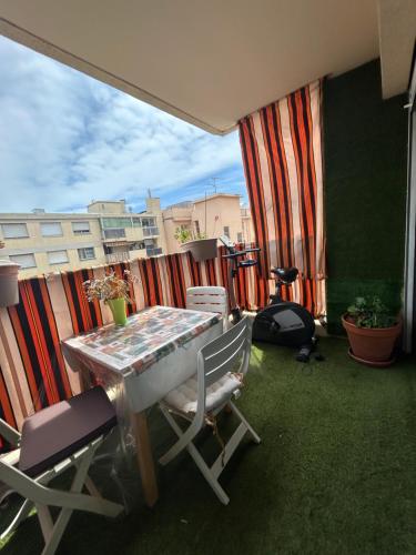 a balcony with a table and chairs on a patio at A room in Nice Beach in Nice
