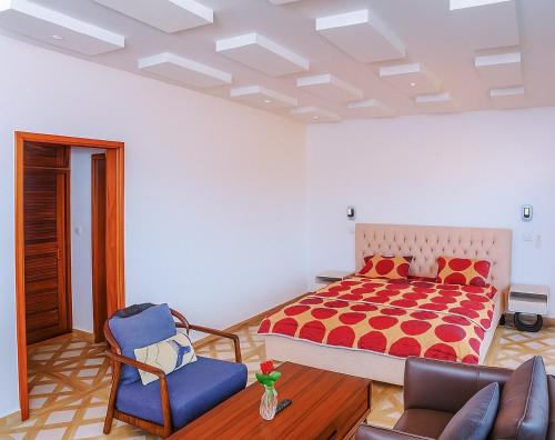 una camera da letto con un letto, un divano e una sedia di Appartement Soleil a Dakar