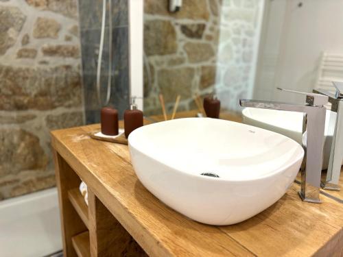 a white sink on a wooden counter in a bathroom at Paços de Douro - Chambre 1 Jardin & Lumière in Romariz