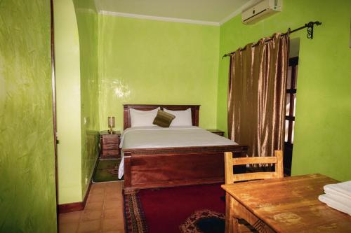a bedroom with a bed in a green room at Bassatine Skoura in Skoura
