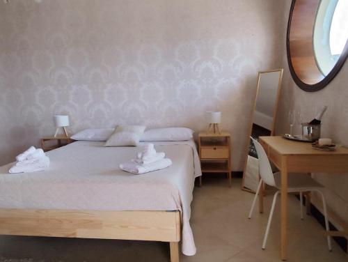 a bedroom with two beds and a table and a mirror at Beautiful Etna's view in San Giovanni la Punta