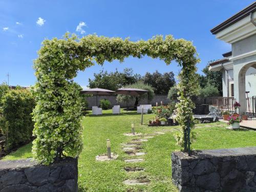 an arch covered in flowers in a yard at Beautiful Etna's view in San Giovanni la Punta