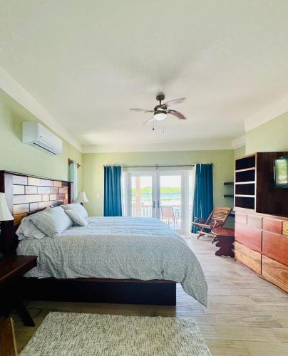 a bedroom with a bed and a ceiling fan at Lina Point Belize Overwater Resort in San Pedro