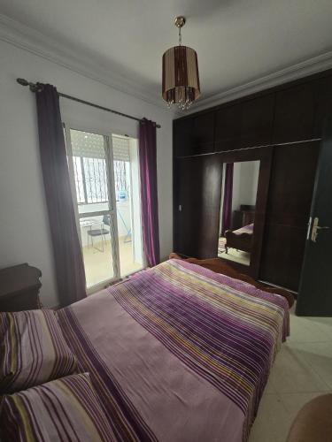 a bedroom with a large bed and a large window at Martil Riad Sofia in Martil