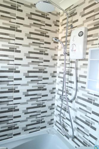 a shower with a glass door in a bathroom at Galleywood House in Great Baddow