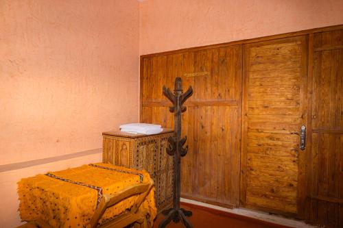 a room with a bed and a wooden door at Bassatine Skoura in Skoura