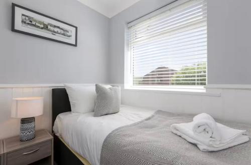 a white bedroom with a bed and a window at Curlew Stays - Semi Detached Home - Pet Friendly in Thornton