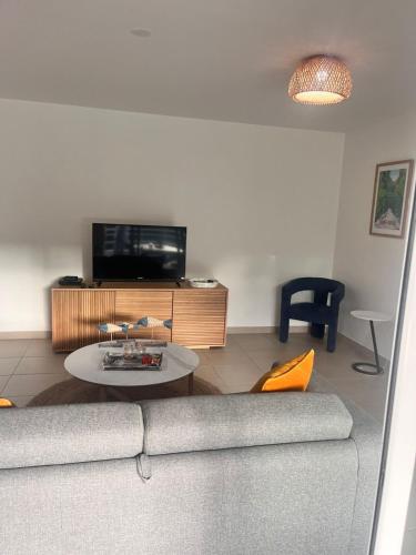 a living room with a couch and a table at Palme bleue t3 au diamant in Le Diamant