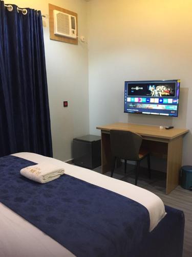 a hotel room with a bed and a desk with a television at Oxbow Apartments 