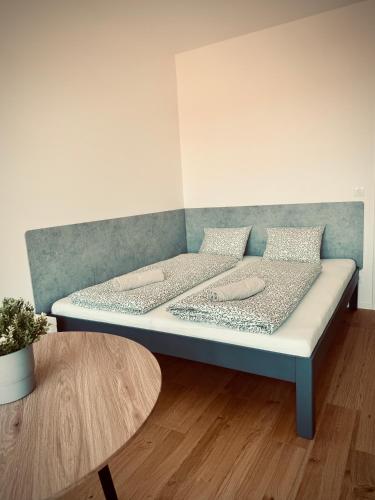 a bed in a room with a table at Pekanda apartment in Brno